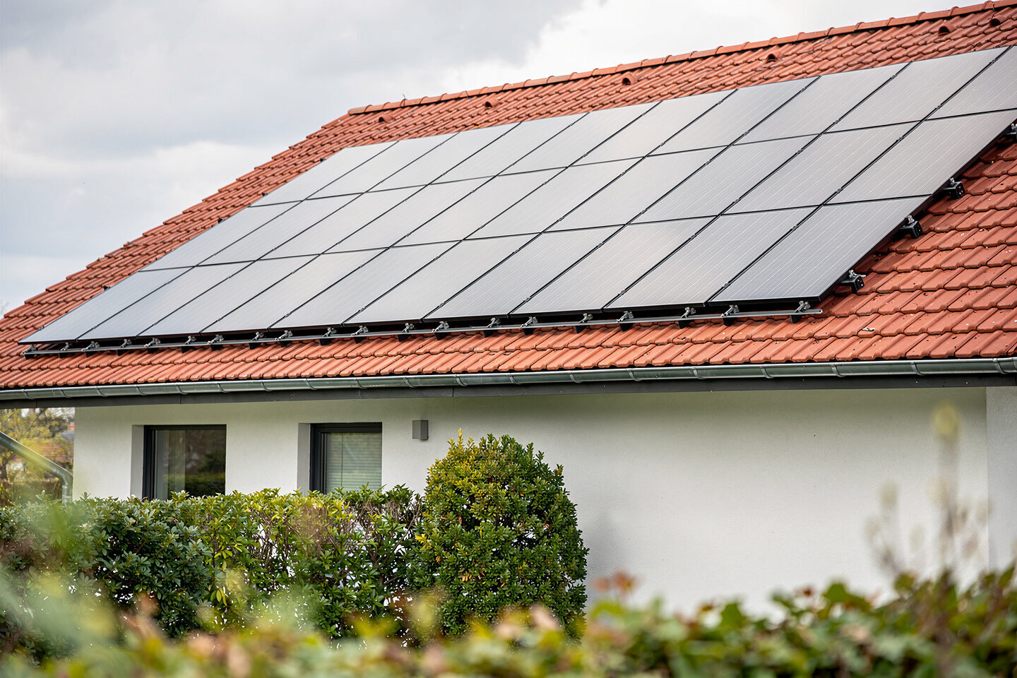 Photovoltaikmodule auf dem Ziegeldach eines Einfamilienhauses